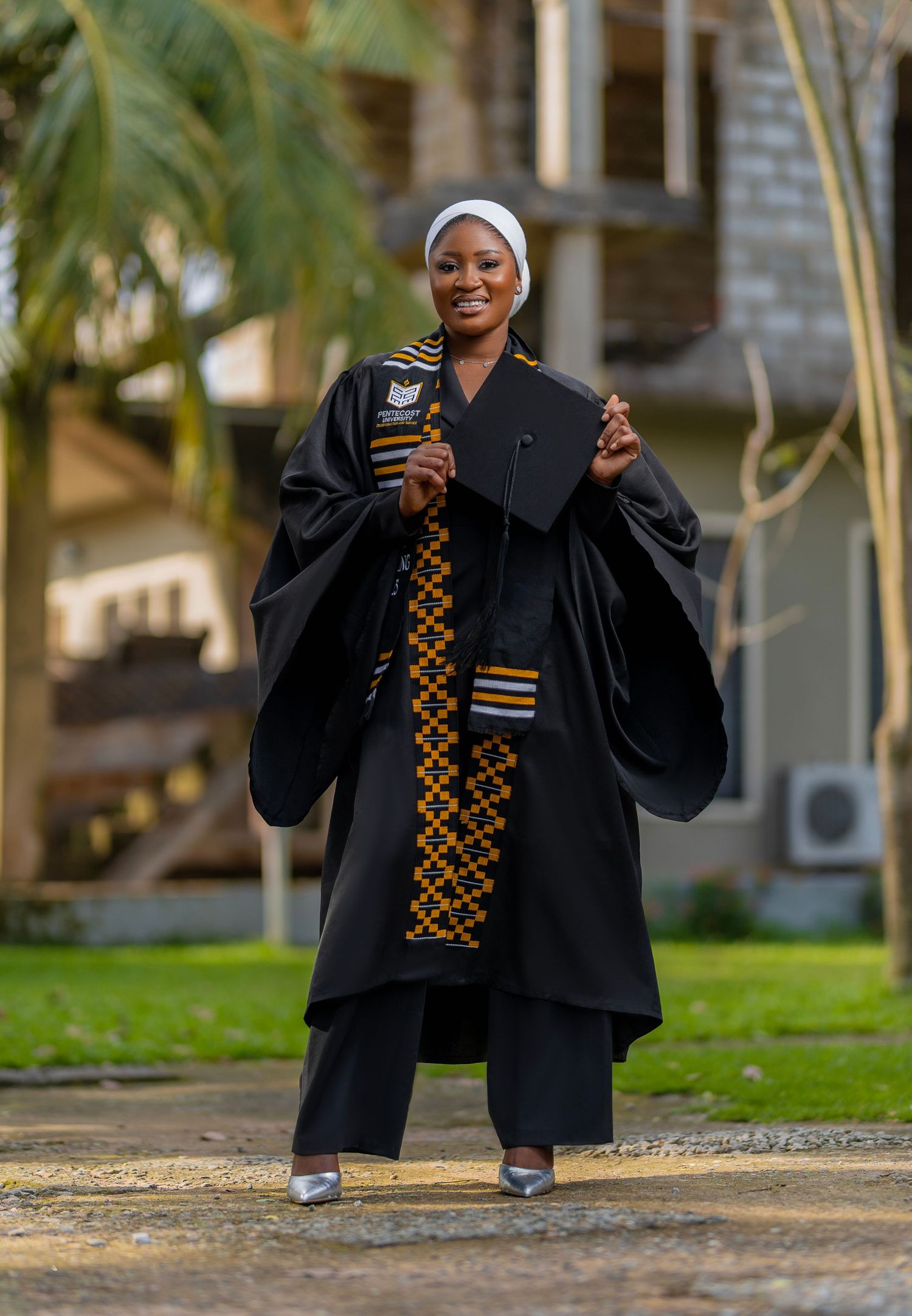 A graduate in academic regalia poses in a sequence of celebratory shots outdoors on campus grounds.