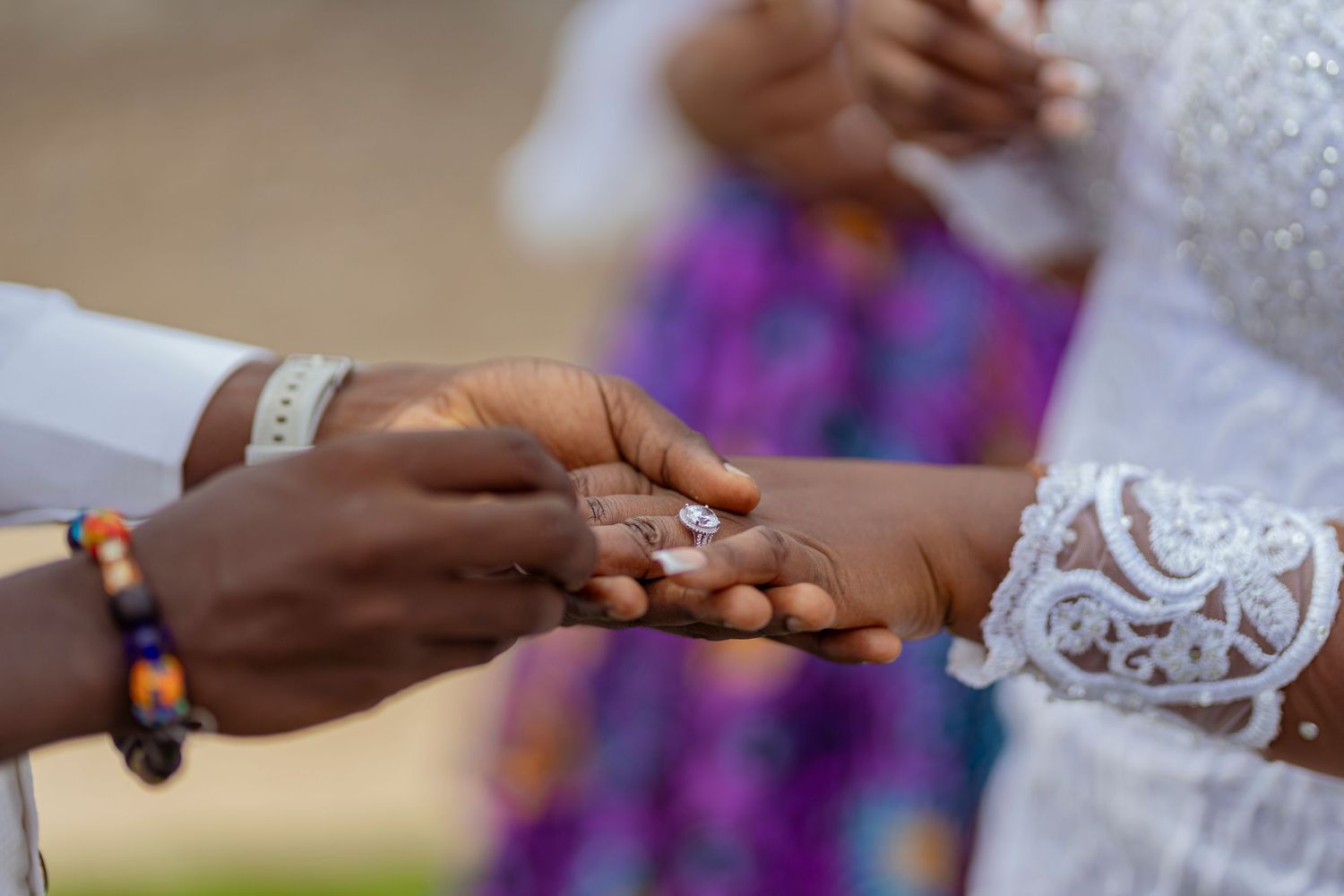 Close-up of hands exchanging rings during a wedding ceremony.