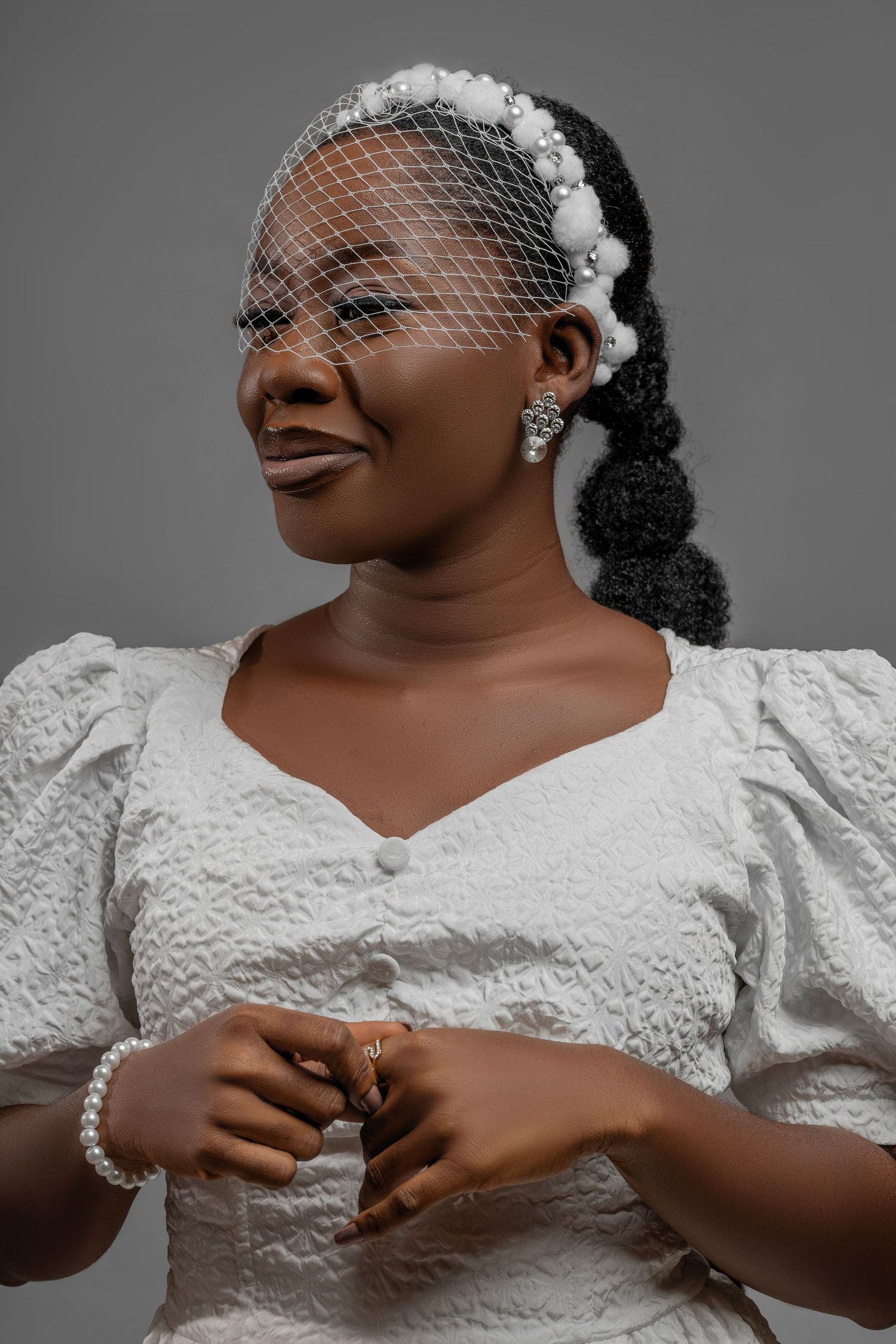 Close-up view of a person wearing a white textured wedding dress with puff sleeves and delicate lace details.