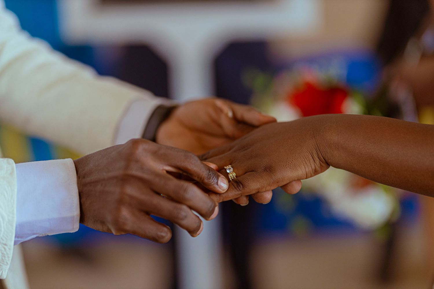 Detailed shot of wedding ring being placed on finger during ceremony.