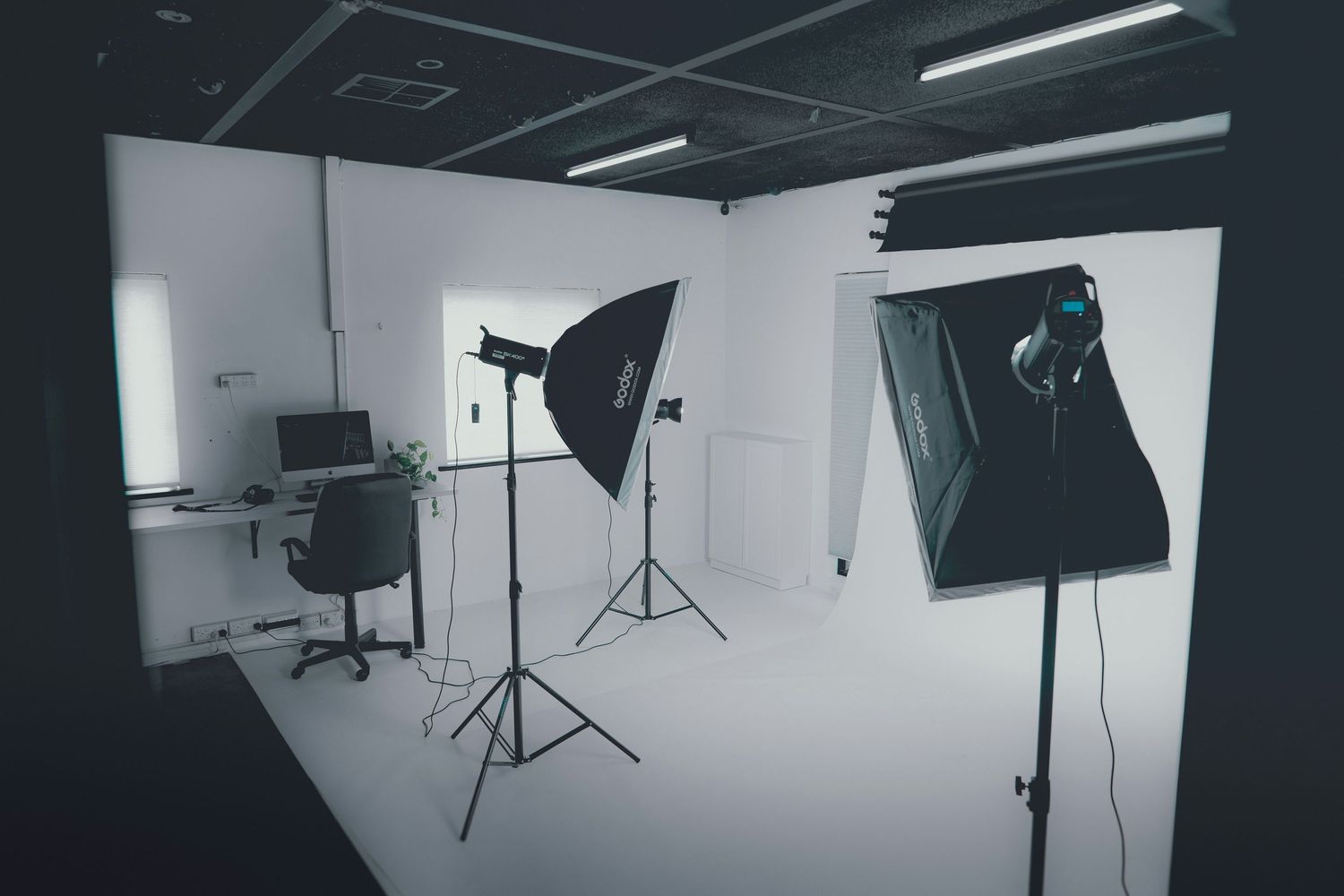 Empty photography studio with softboxes and lighting equipment set up.