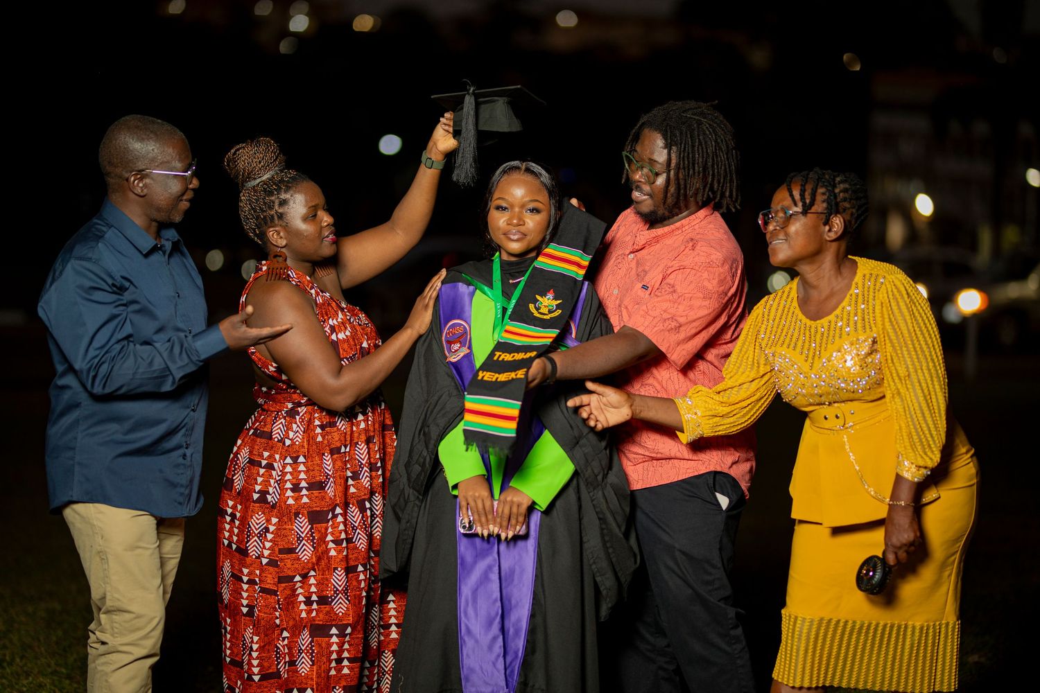 A group of people dancing and socializing together at a nighttime outdoor gathering.