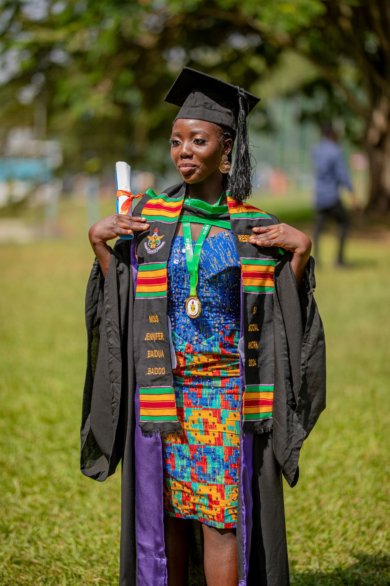 Graduate wearing colorful kente stole and academic regalia poses outdoors in sequence of celebratory shots.