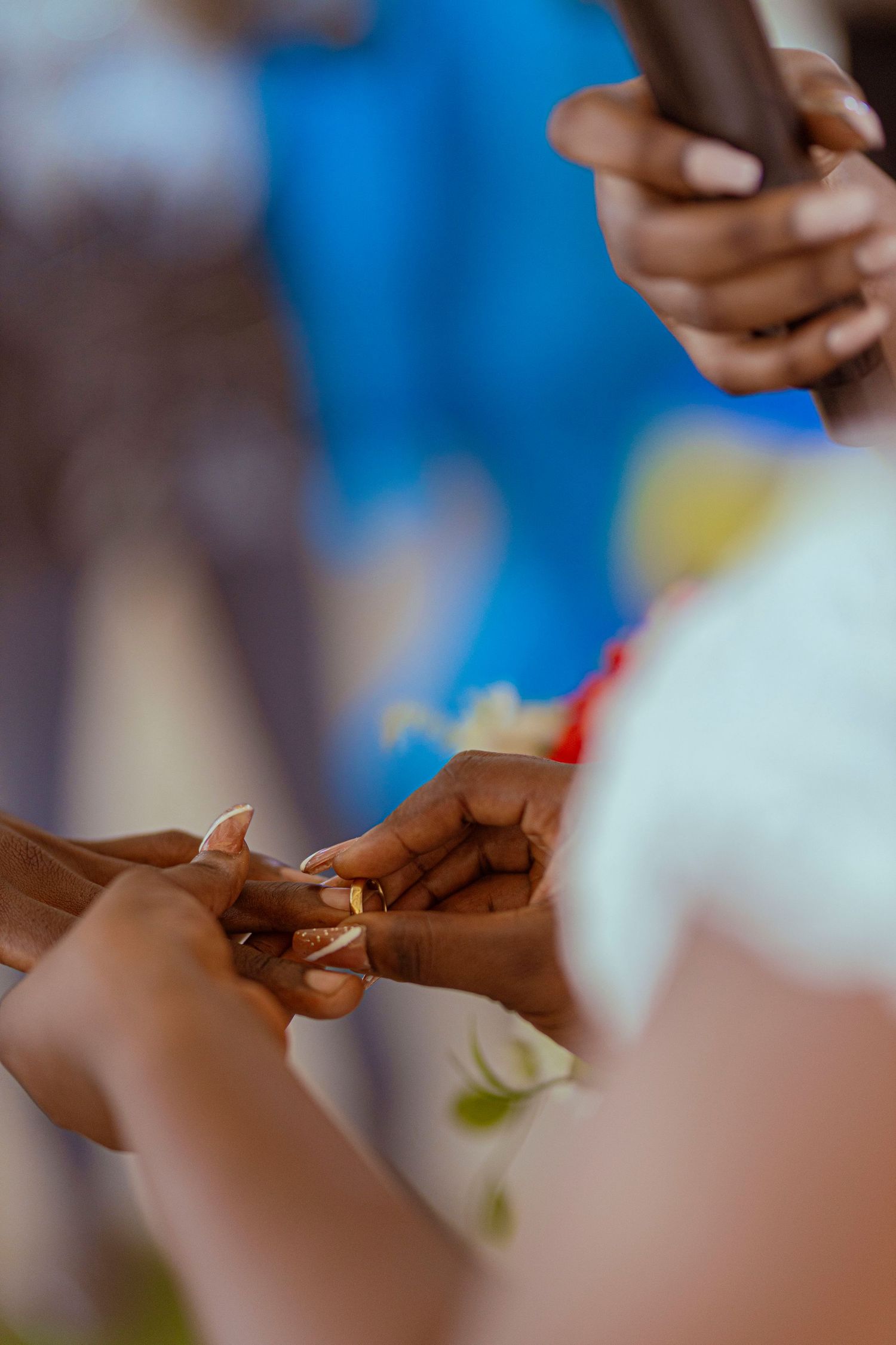Close-up shot of hands during a ring exchange ceremony.