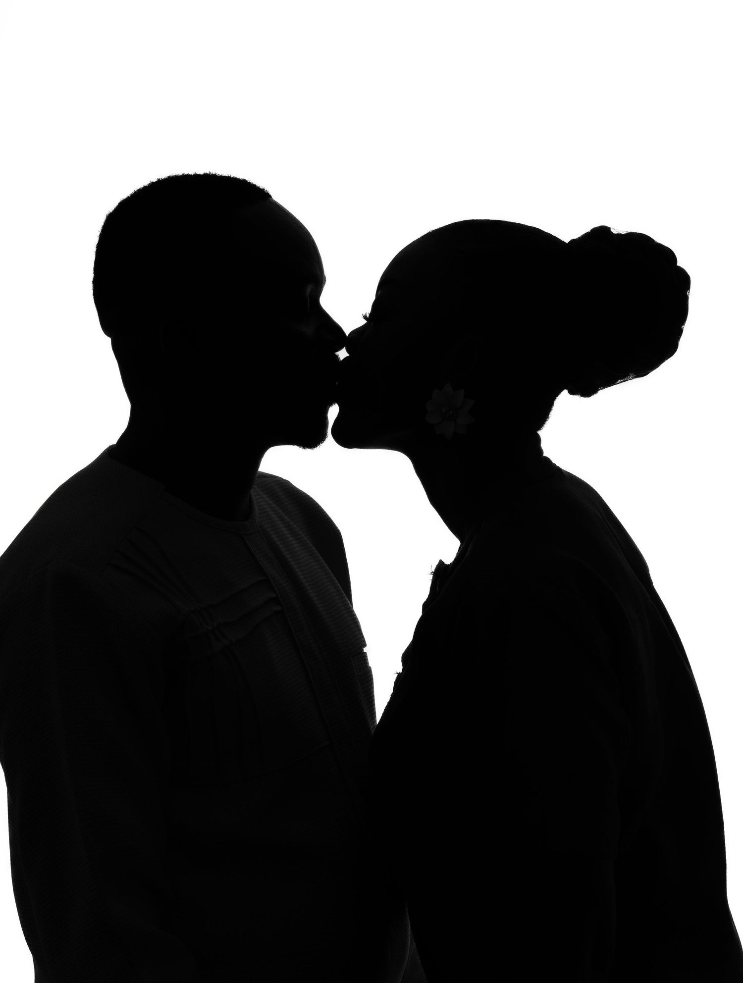 Silhouetted figures in profile create a dramatic black and white composition against a light background.