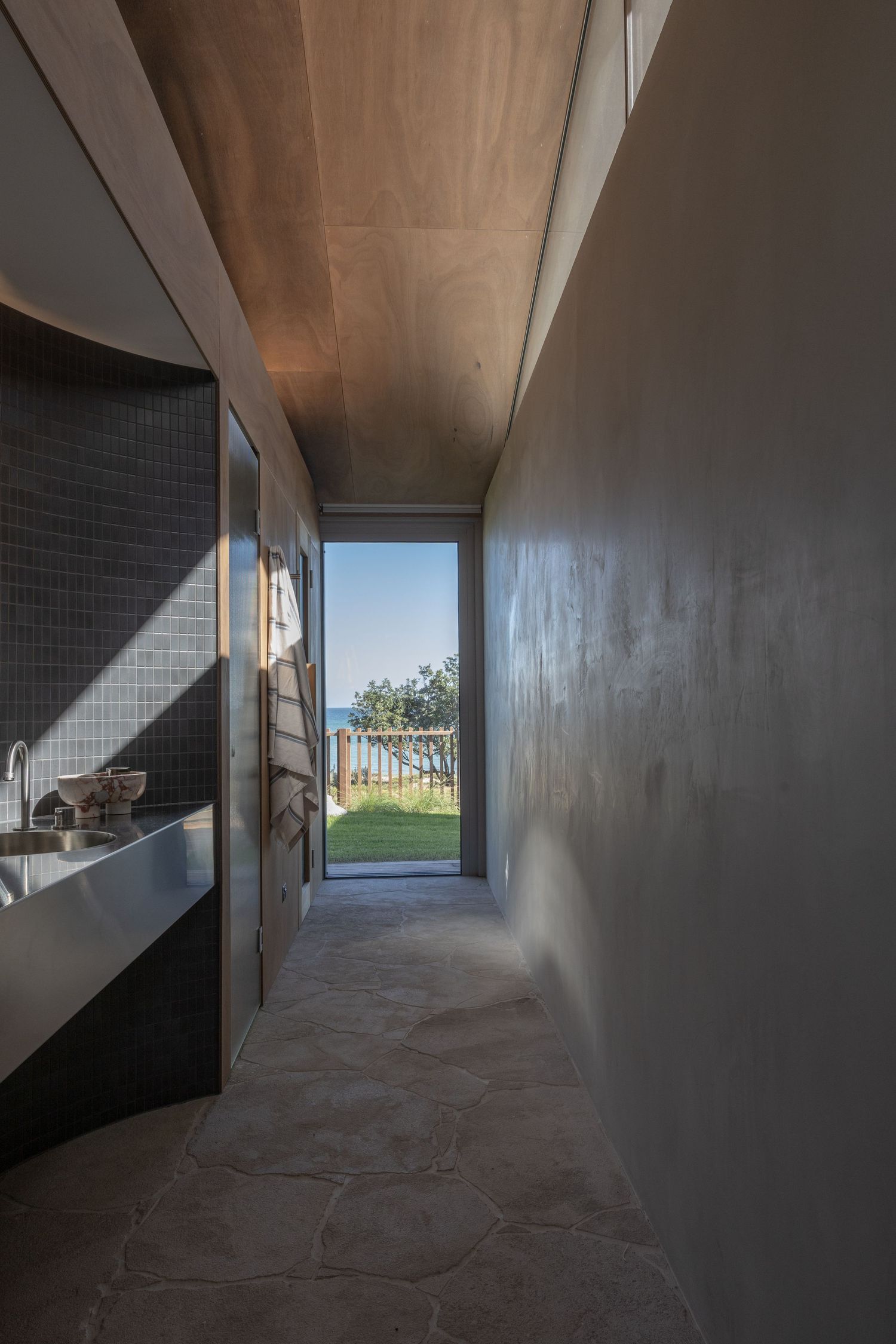A series of dark concrete hallway perspectives showing distant sunlit windows at the end of each corridor.