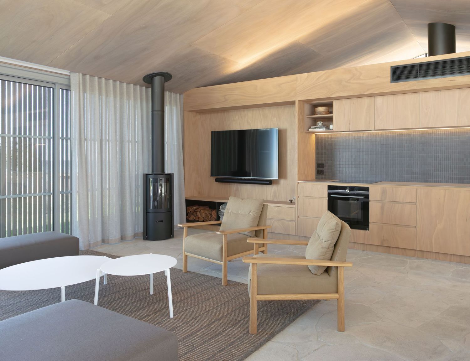 Modern minimalist room interior with wooden slat walls, recessed lighting, and built-in storage features.