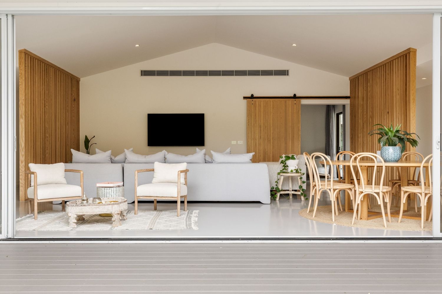 Modern minimalist living room interior with wooden accents and white walls features sleek furniture and natural lighting.