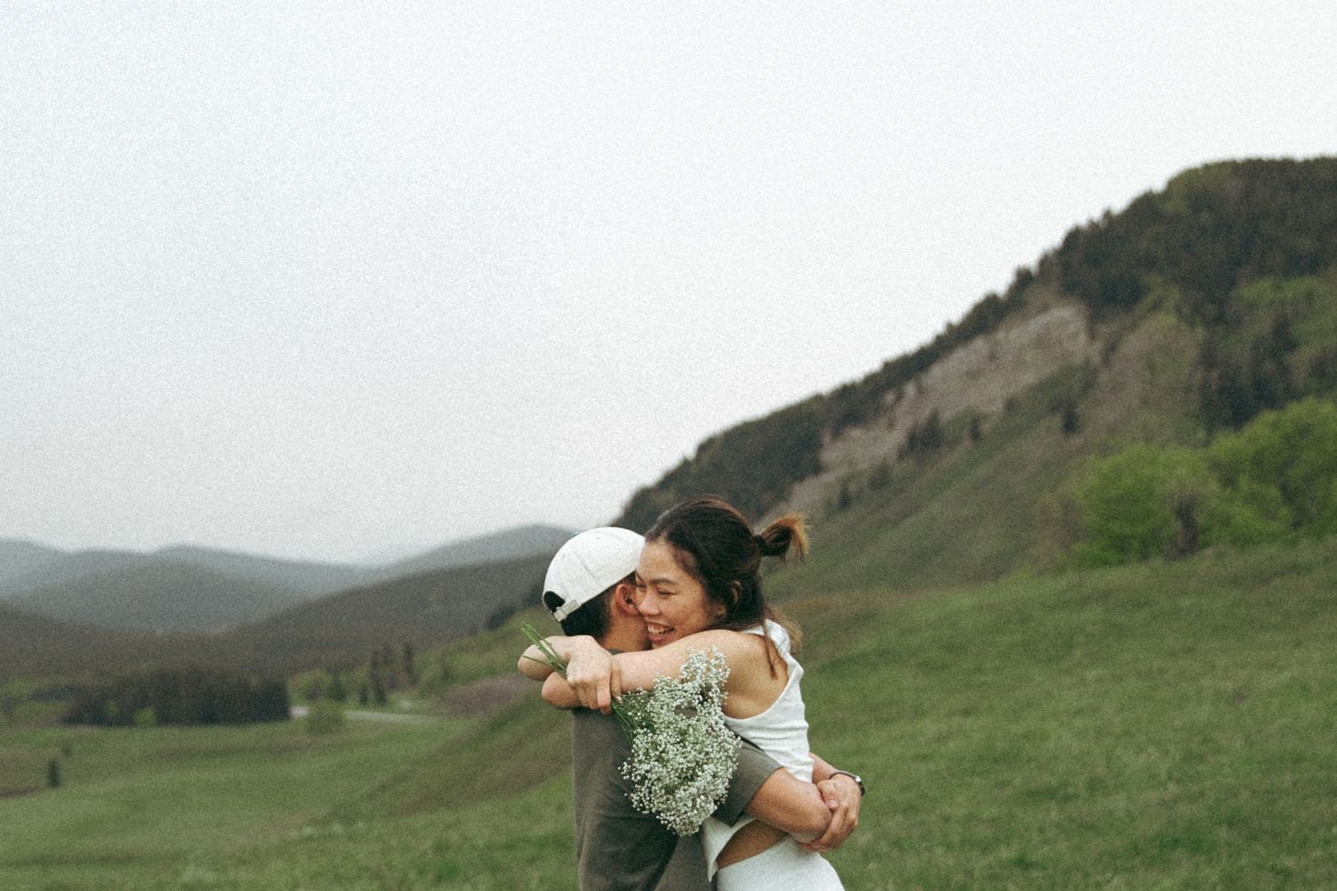 Joyful embrace captured during a mountain wedding photoshoot.