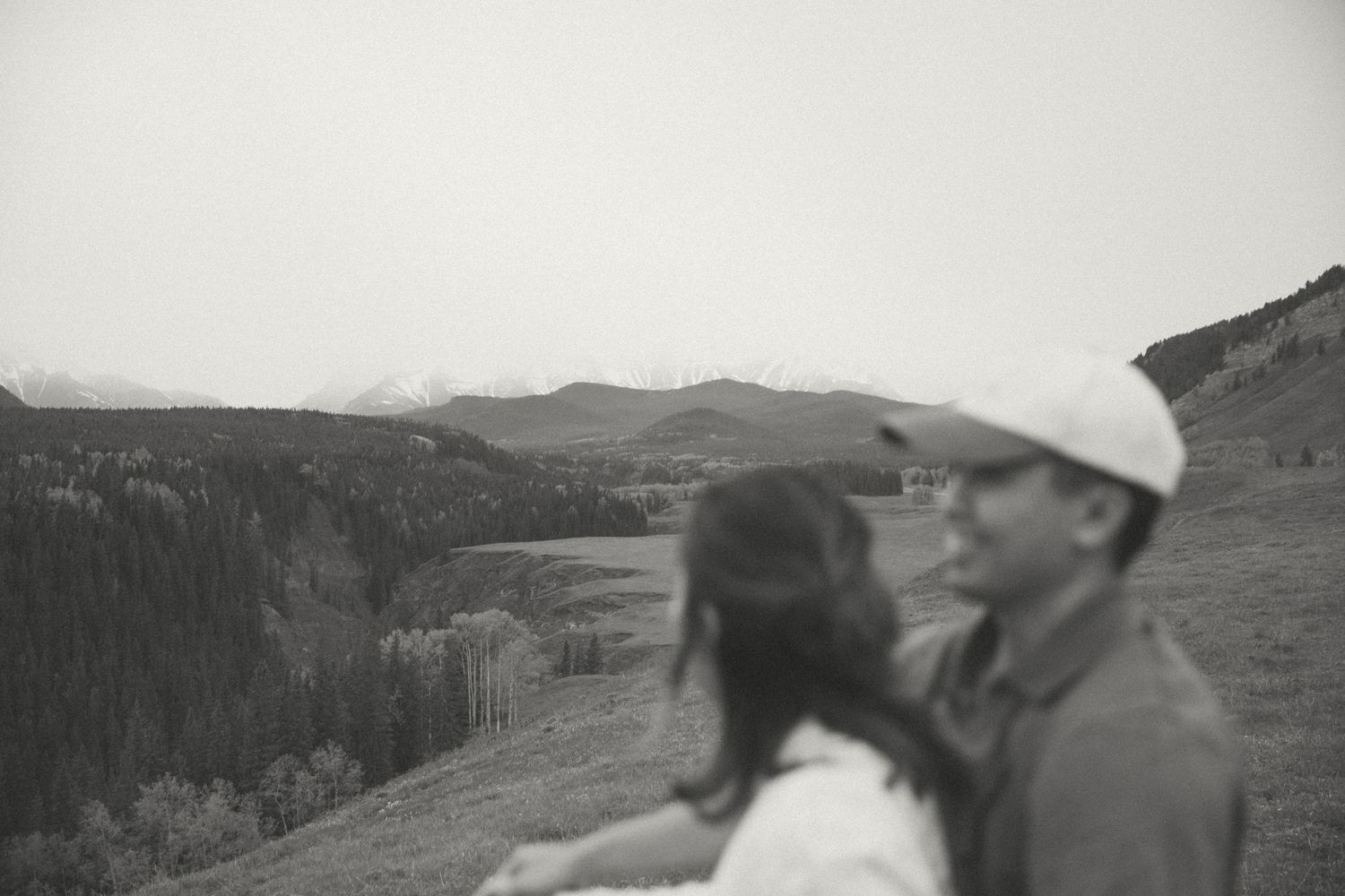 Black and white photo of two people enjoying mountain scenery together.
