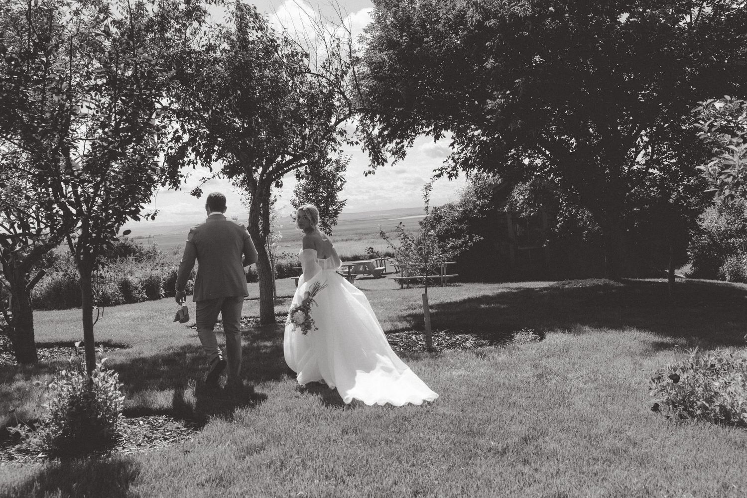 Black and white wedding photography captures outdoor moments in a natural setting.