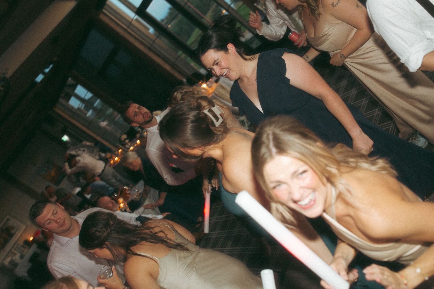 Reception attendees celebrate and pose with glow sticks during the party.