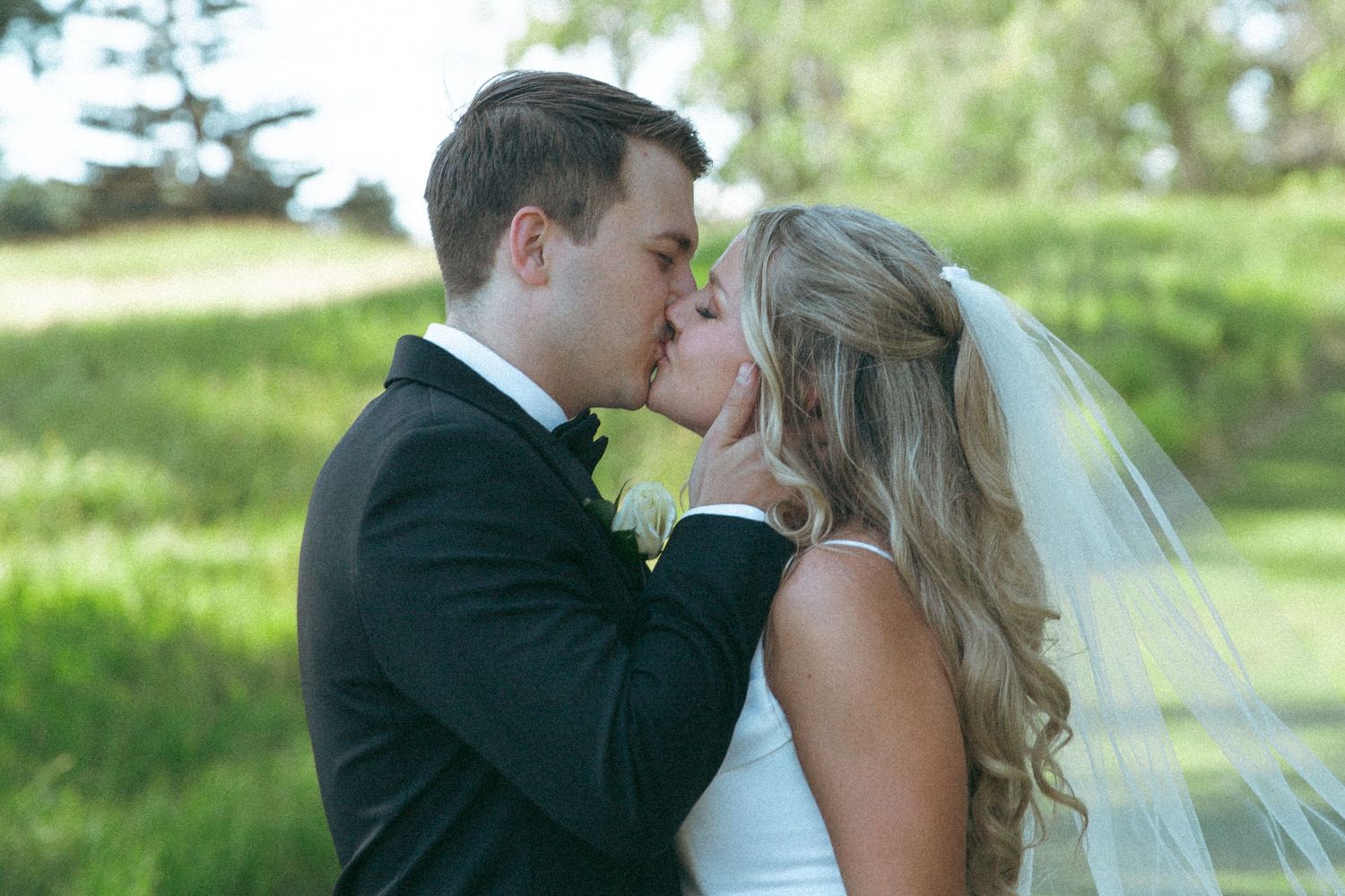 A romantic wedding moment captured in golden sunlight with flowing veil.