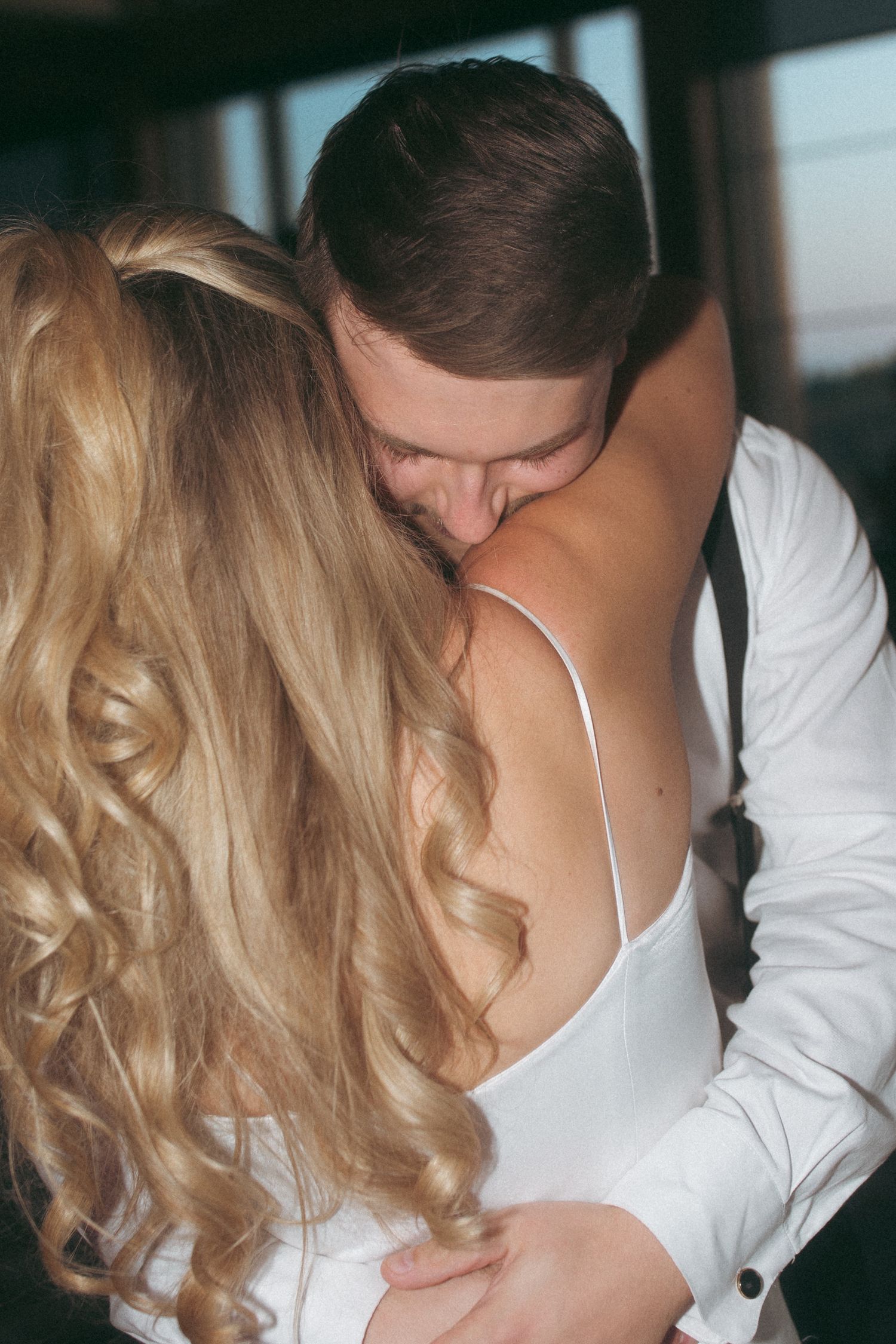 A romantic moment captured between two people in formal wedding attire.