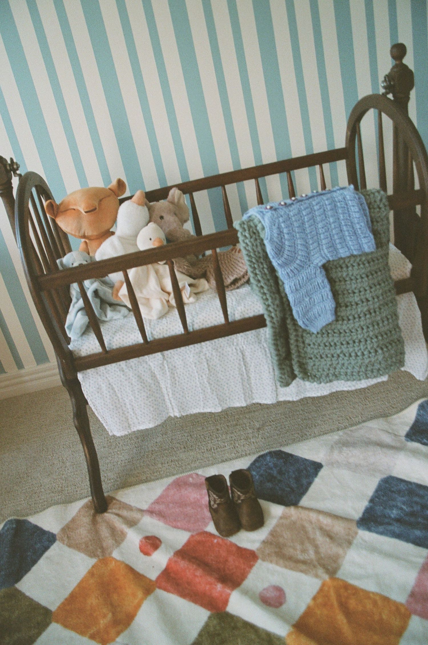 A series of vintage photographs showing a wooden crib with stuffed animals and a patchwork quilt in a blue striped room.