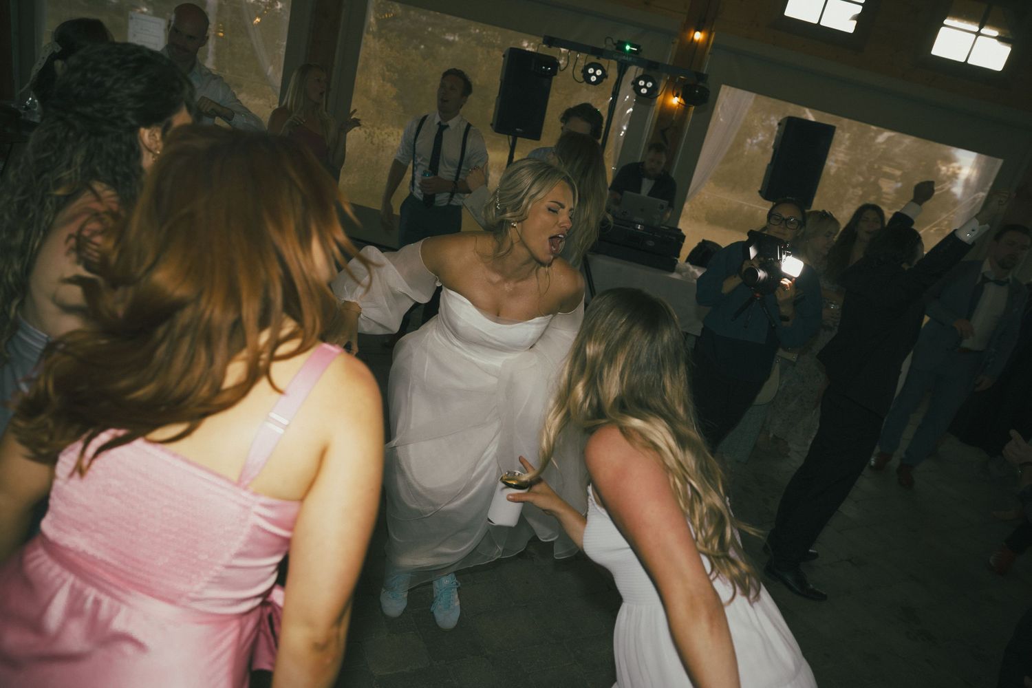 A lively dance party scene with people dancing in a dimly lit venue.