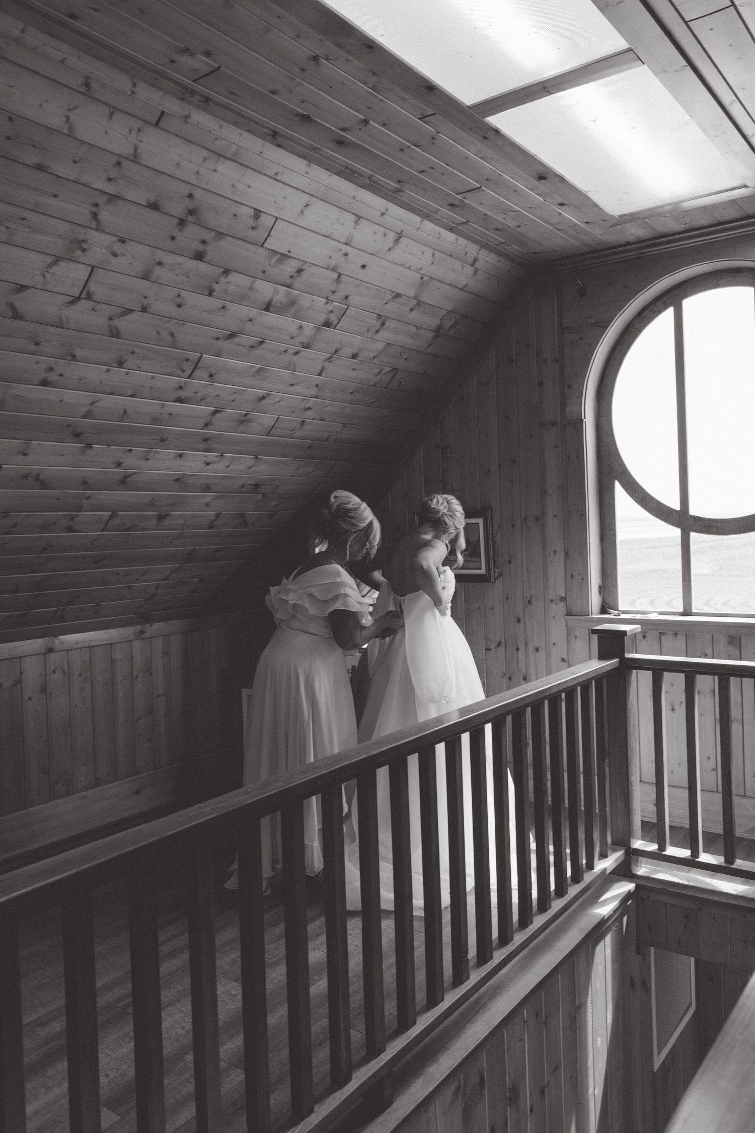 A series of black and white photos showing a couple in wedding attire looking out a rustic wooden window.