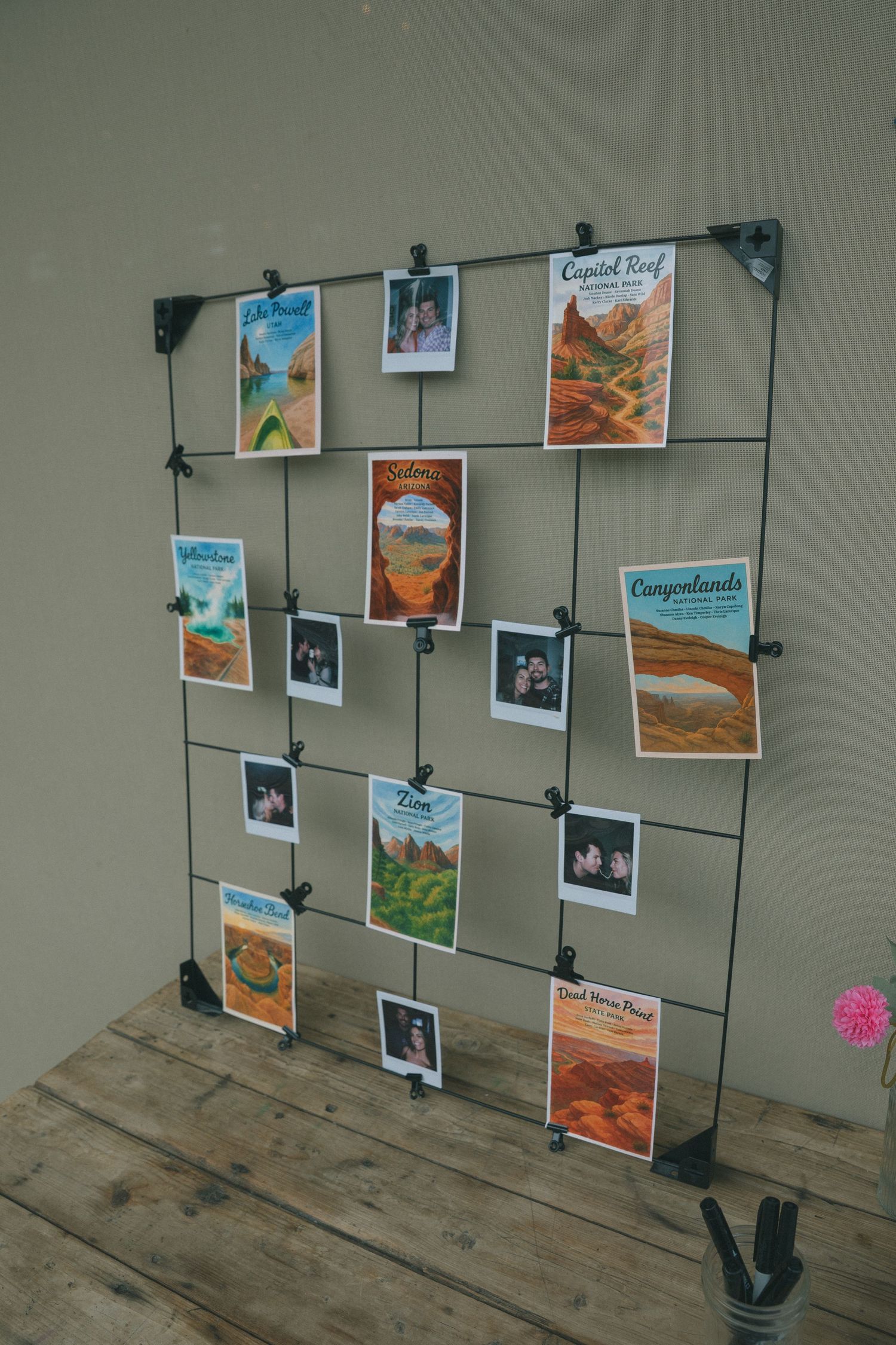 Photo display wall with wire grid system showing travel and food images clipped with black clips.