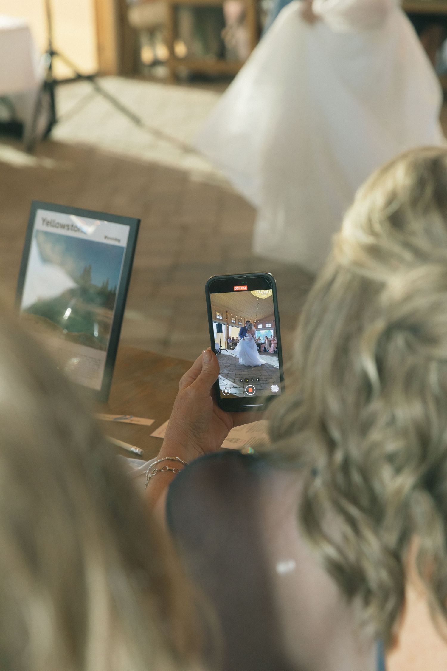 Someone holding a smartphone to capture a photo during what appears to be a wedding preparation.