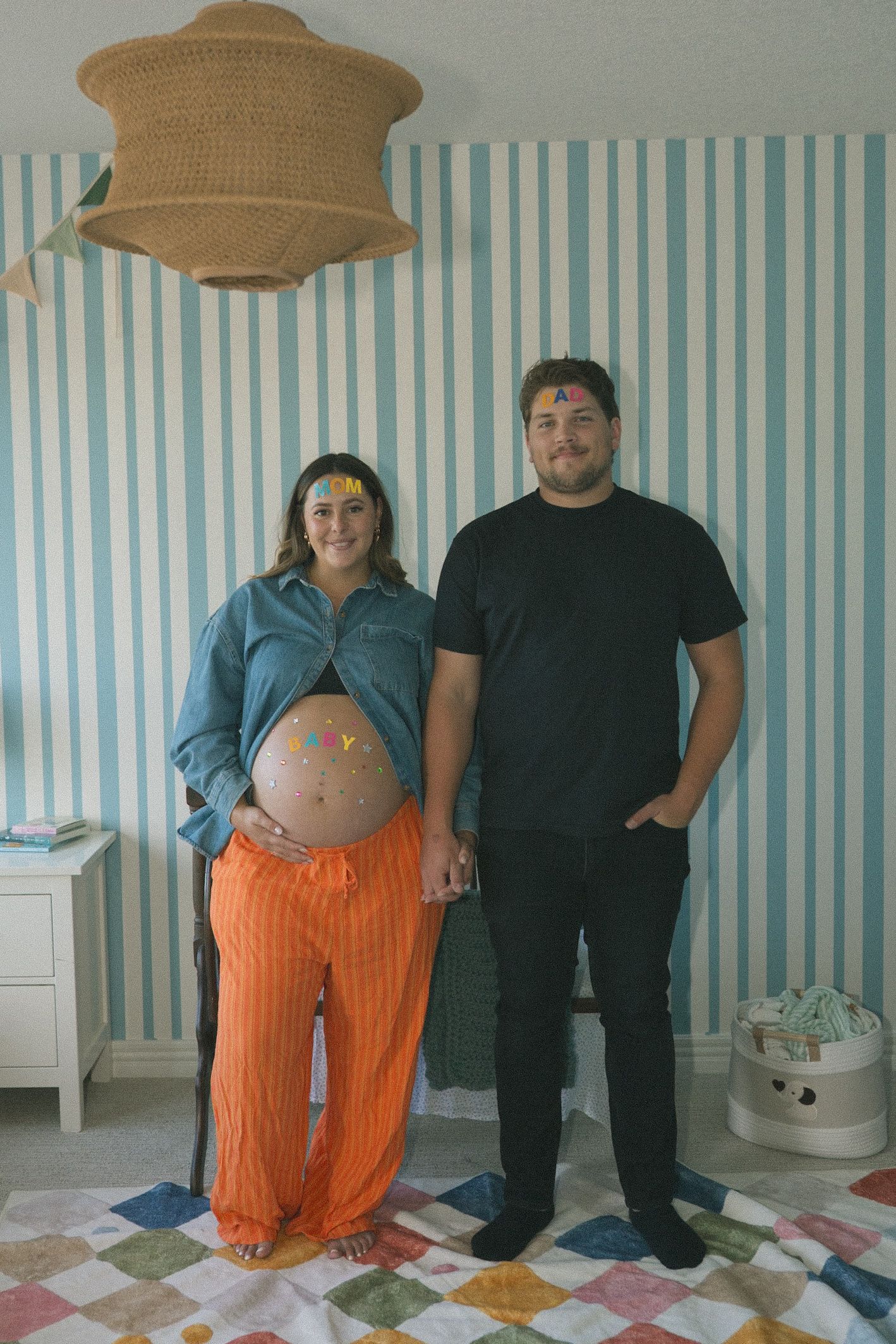 A sequence of pregnancy progression photos showing people standing against a blue and white striped wall.