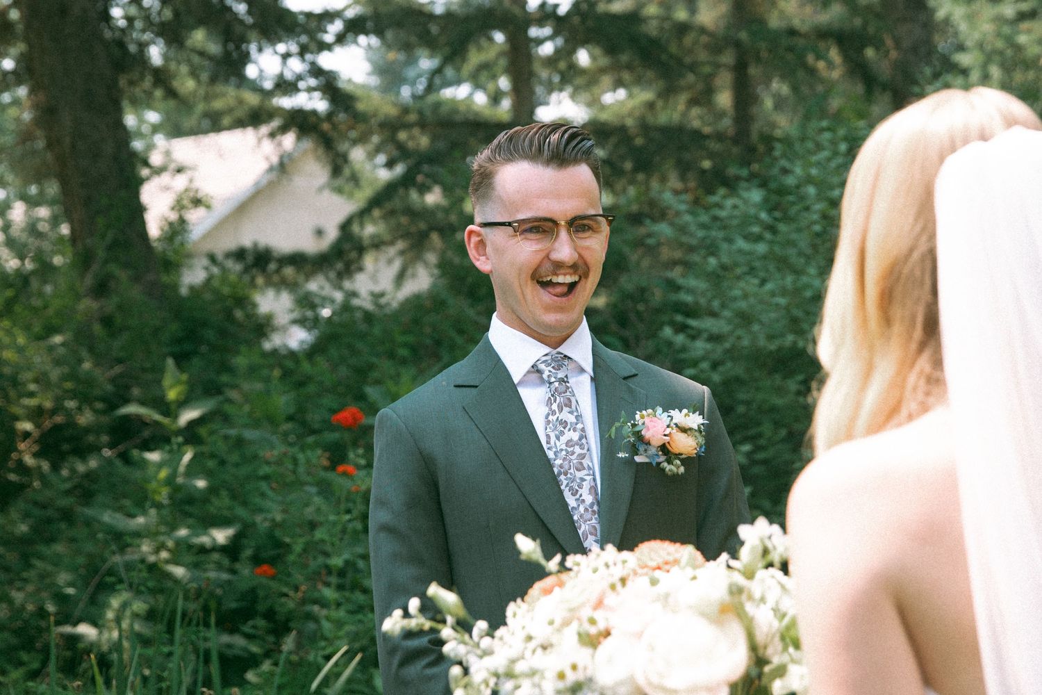 An intimate wedding moment captured in a garden with colorful flowers and greenery.