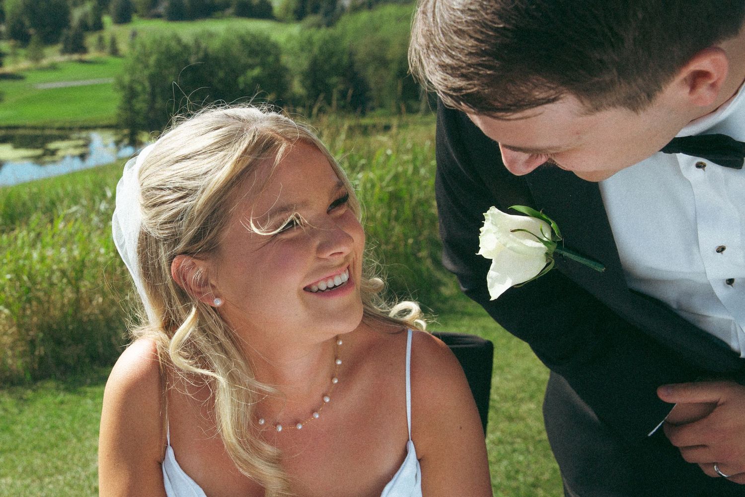 Candid moment between newlyweds sharing laughter on their wedding day.