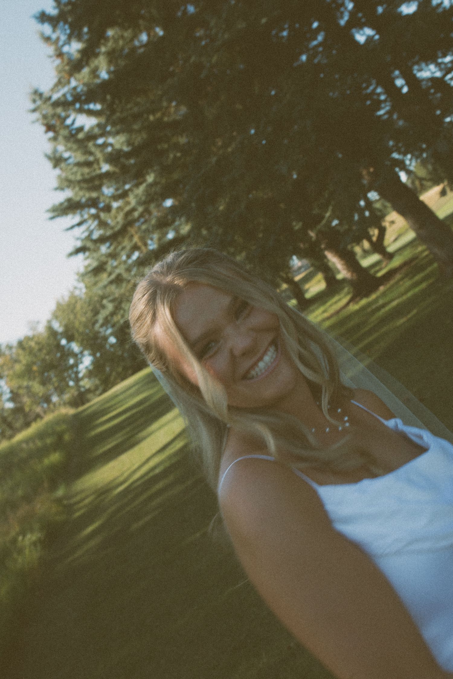 Close-up wedding photo taken outdoors with natural lighting and trees in background.