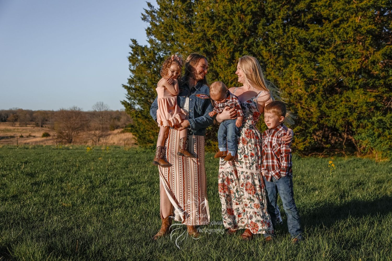 A sweet outdoor family photo session in a field during golden hour.