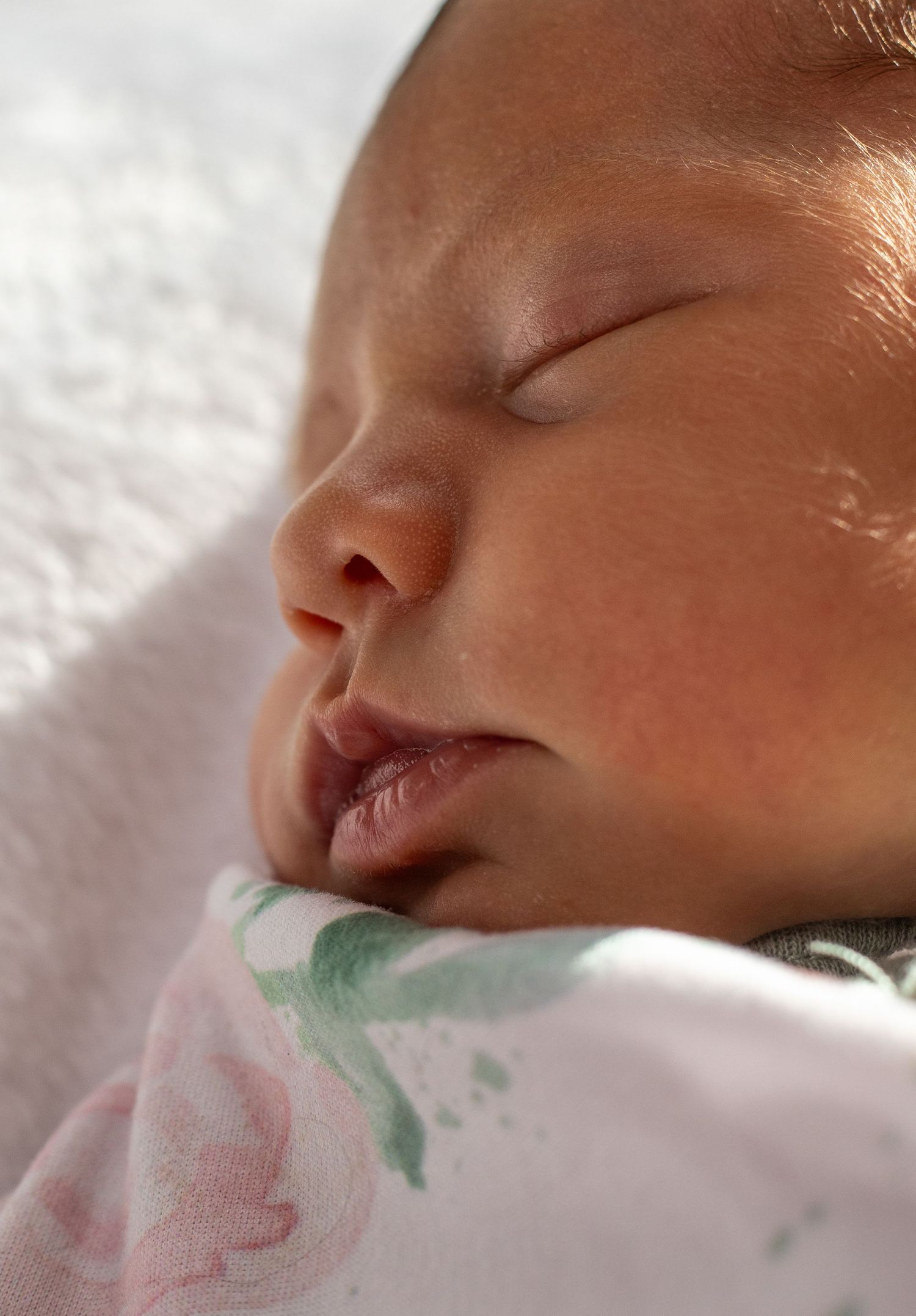 A close-up series showing a sleeping newborn's face from different angles against a white background.