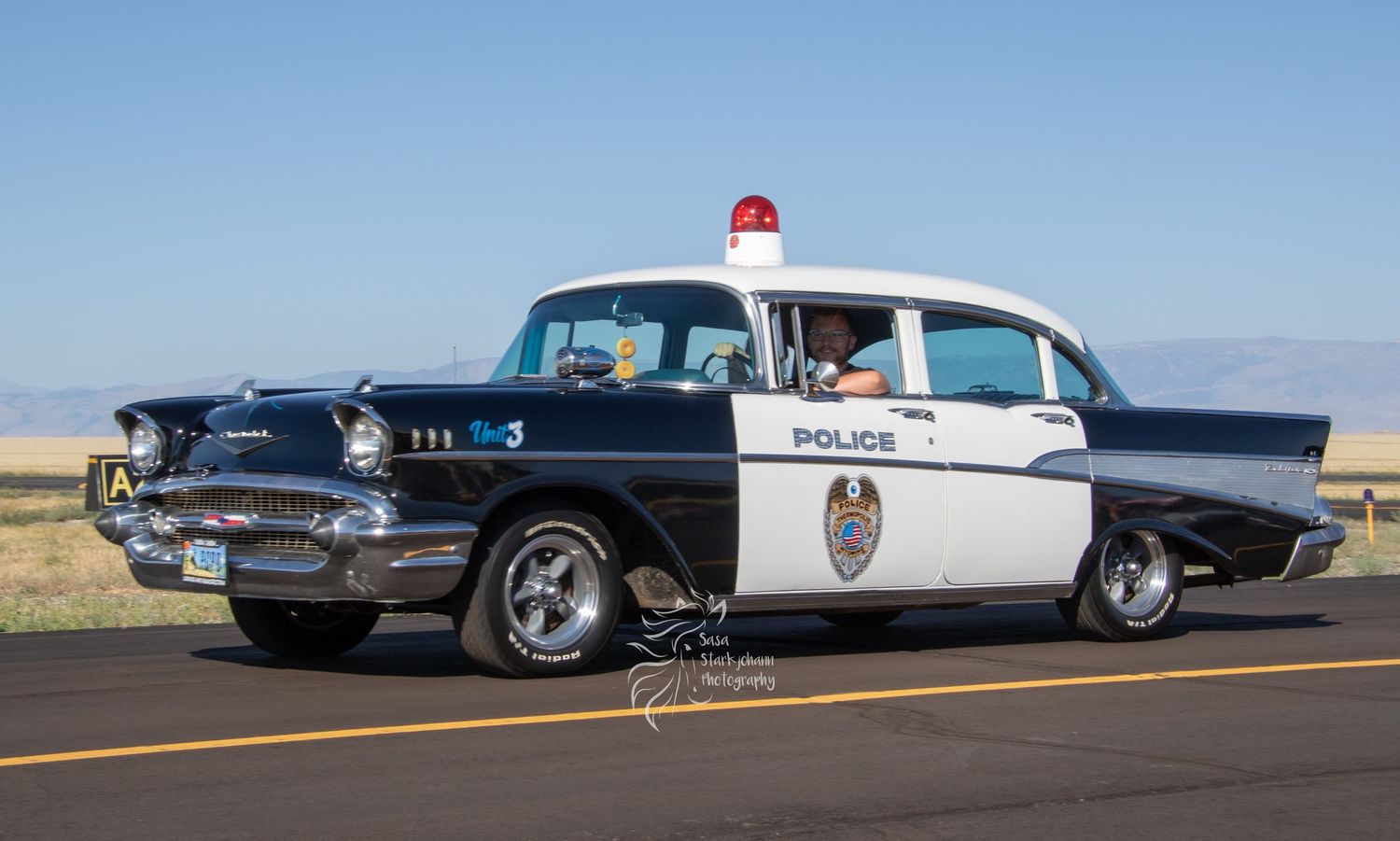 Vintage 1957 Chevrolet police car in classic black and white patrol car livery.