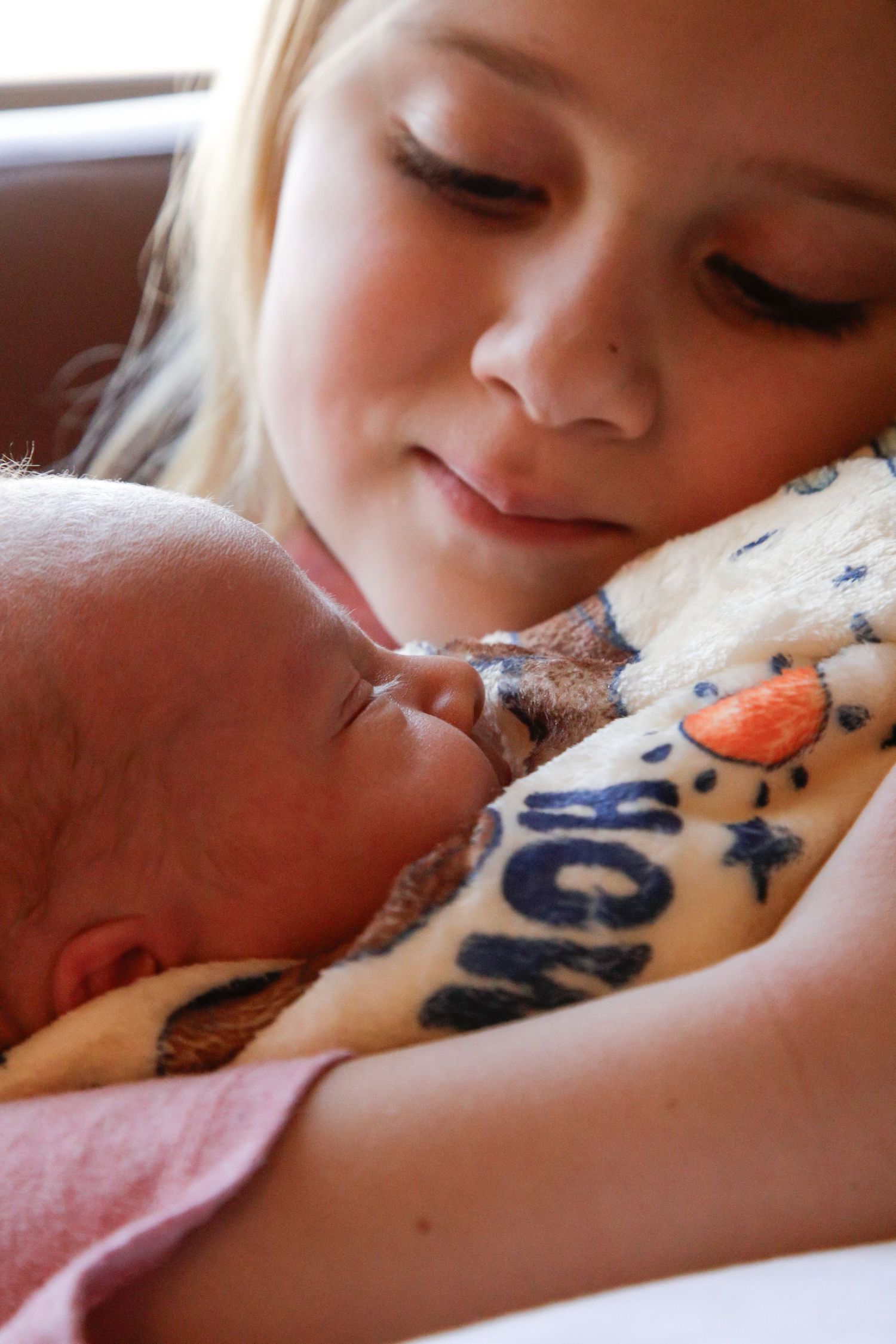 A tender moment captured between a baby and caregiver in soft natural lighting.