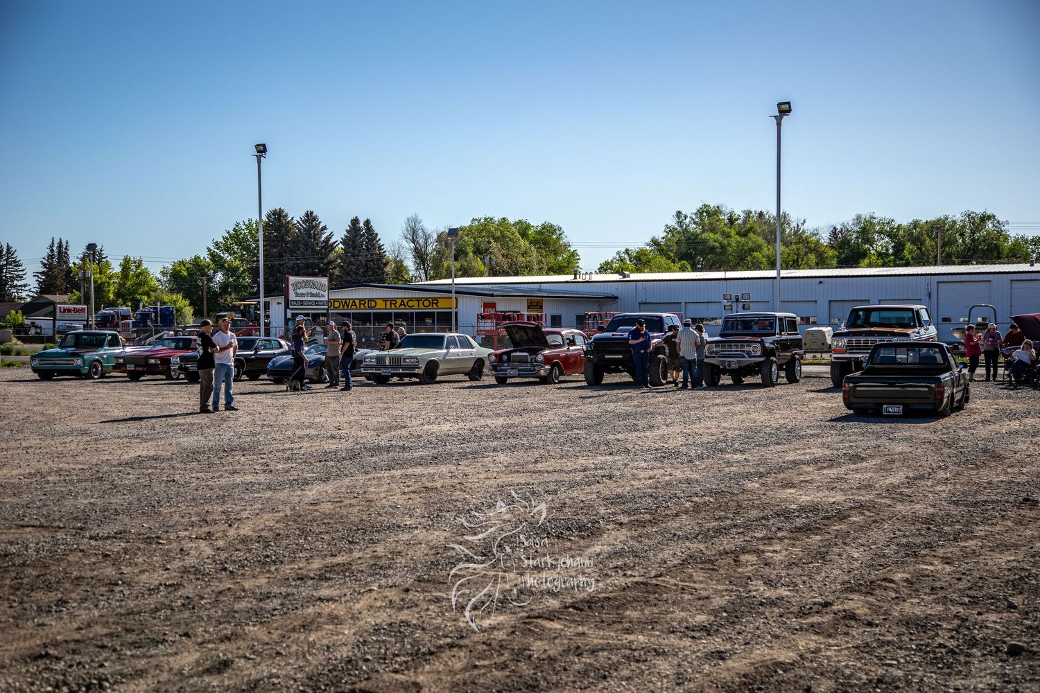 Cars and trucks parked outside a small town gas station and convenience store on a sunny day.