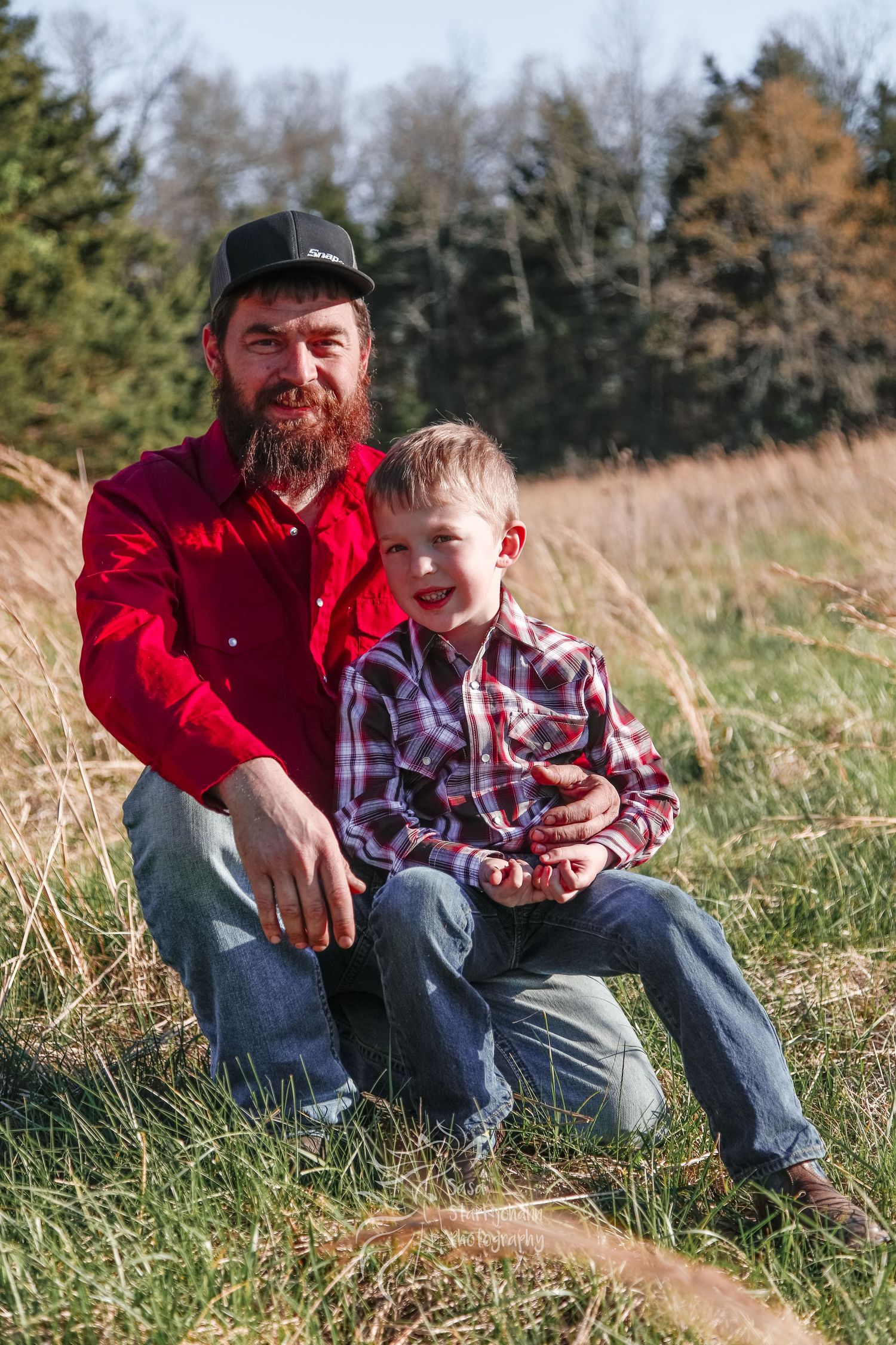 A heartwarming moment shared between parent and child sitting in tall grass.