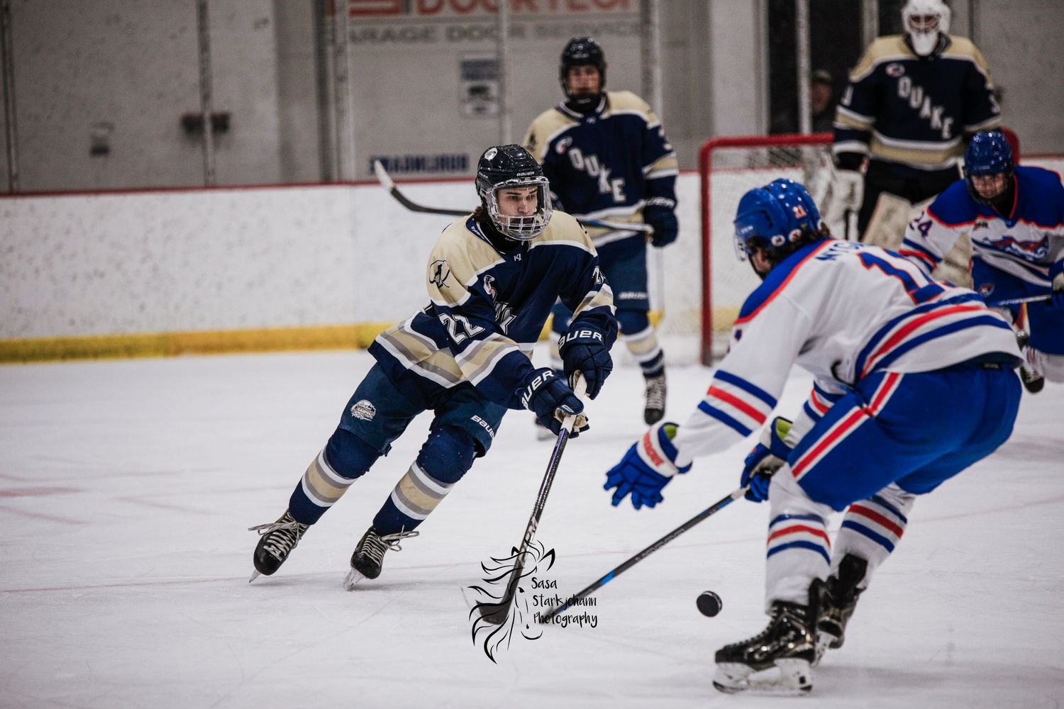 Hockey players from opposing teams compete for the puck during an intense game.