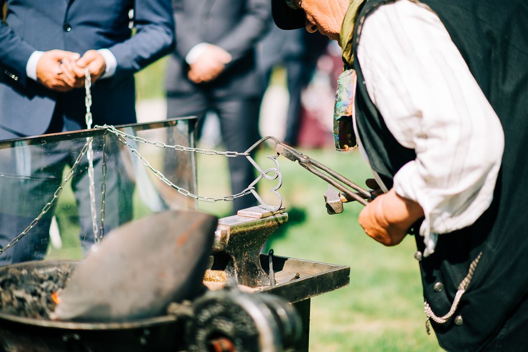 Close-up of traditional blacksmithing tools and metalwork during outdoor demonstration.