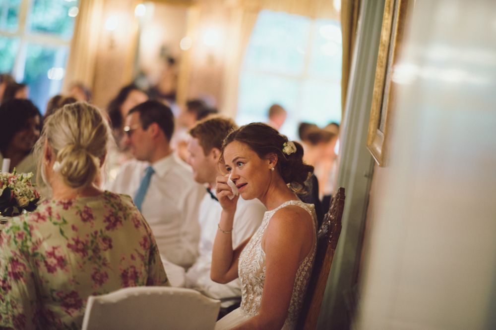 Elegant wedding reception dinner at a formal venue with soft lighting and decorative table settings.