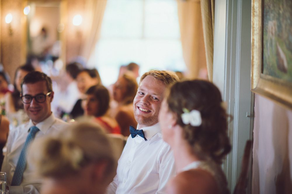 Wedding reception guests share laughs during indoor celebration.