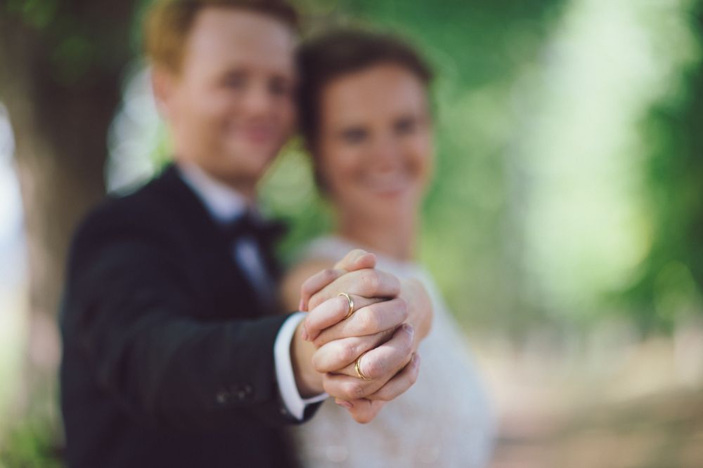 Close-up of clasped hands during a romantic wedding moment.