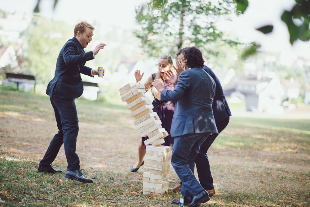 Wedding guests play an energetic outdoor game during daytime celebration.