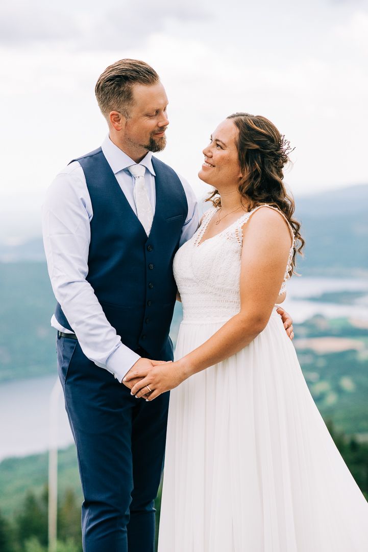 Intimate wedding portrait with mountain lake vista in background.