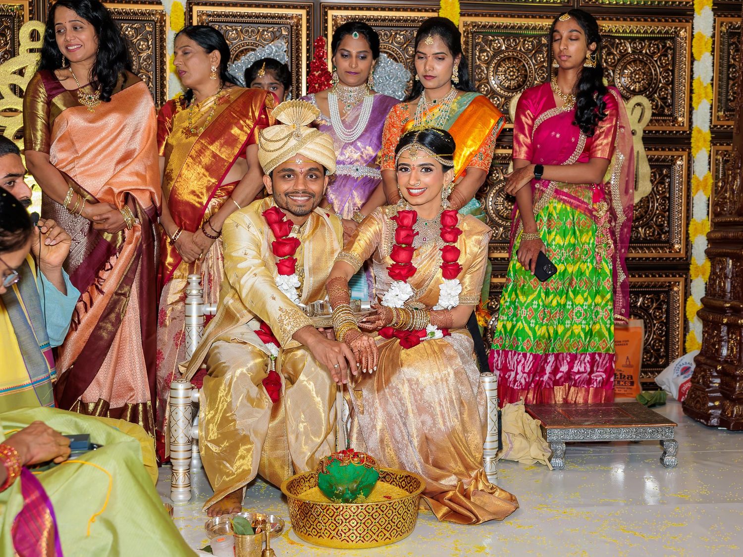 Wedding attendees in vibrant traditional Indian attire gathered for ceremonial photographs.