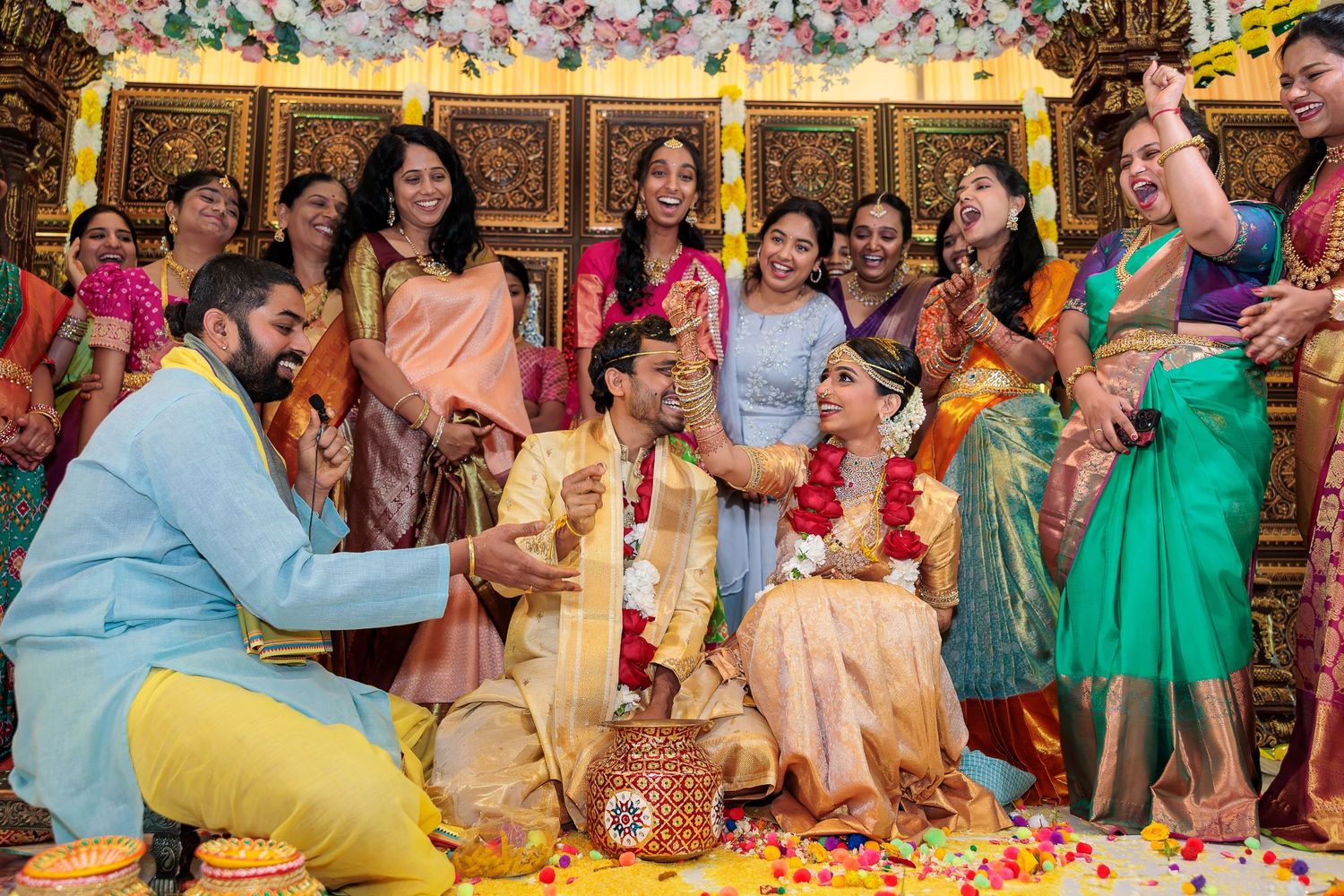Joyous celebration during Indian wedding with guests wearing colorful traditional attire.