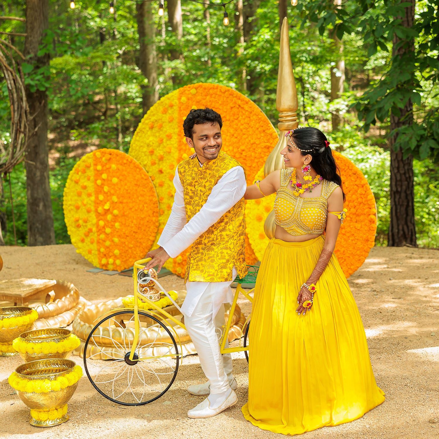 Festive yellow and orange marigold decor with traditional Indian brass vessels in an outdoor wedding setting.