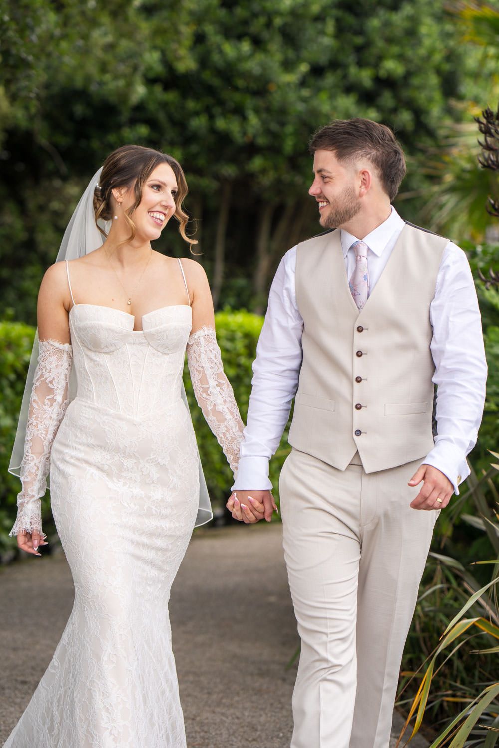 A joyful couple walking hand in hand during their wedding at Christchurch Harbour hotel, Dorset