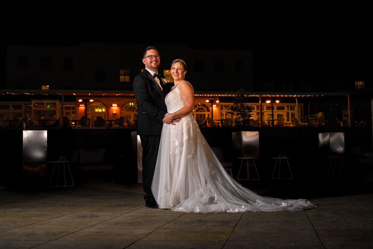 A couple poses together at night on their wedding day at the Christchurch Harbour hotel in Dorset.