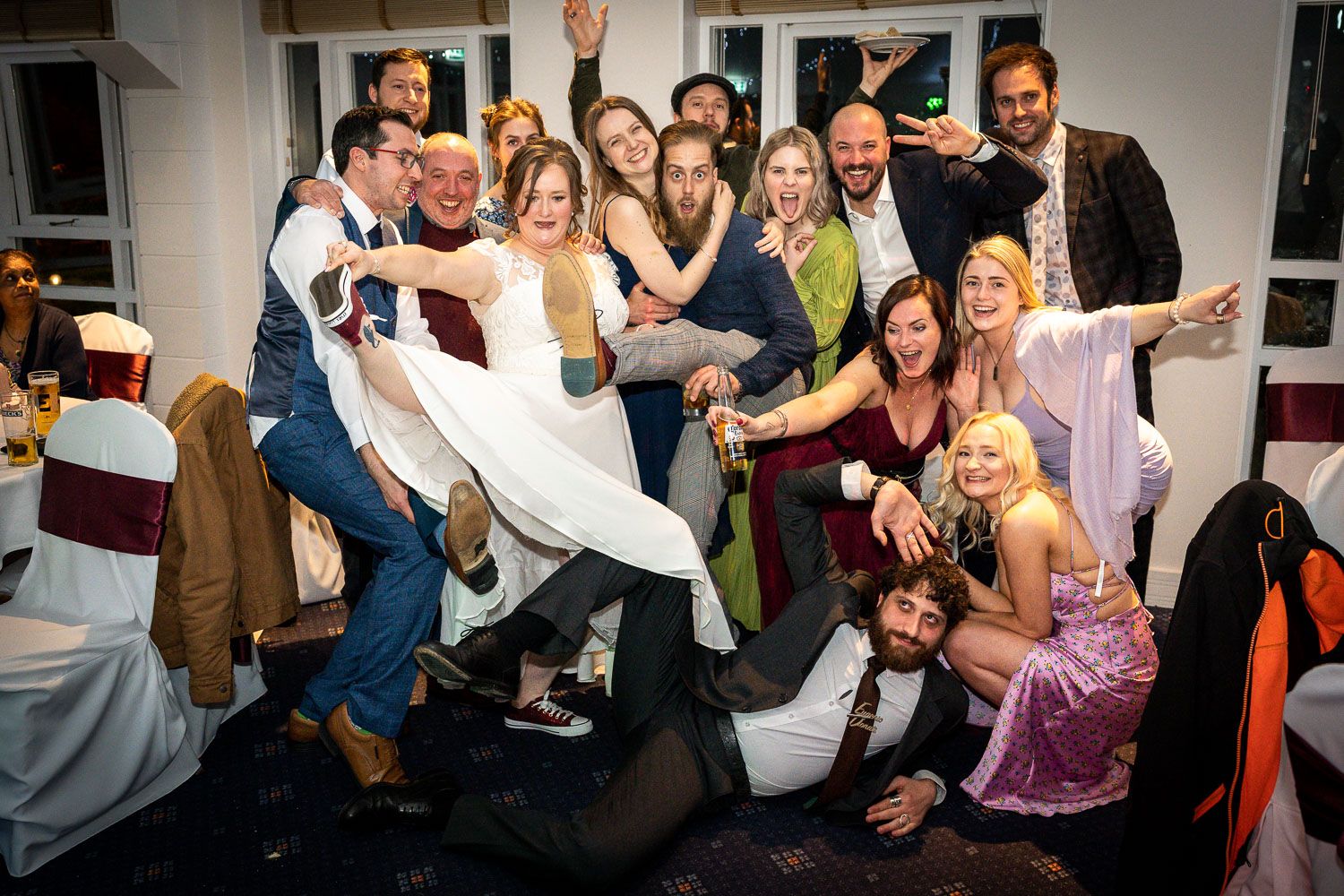 Fun wedding party group photo shows guests celebrating and posing together during a lively reception celebration.