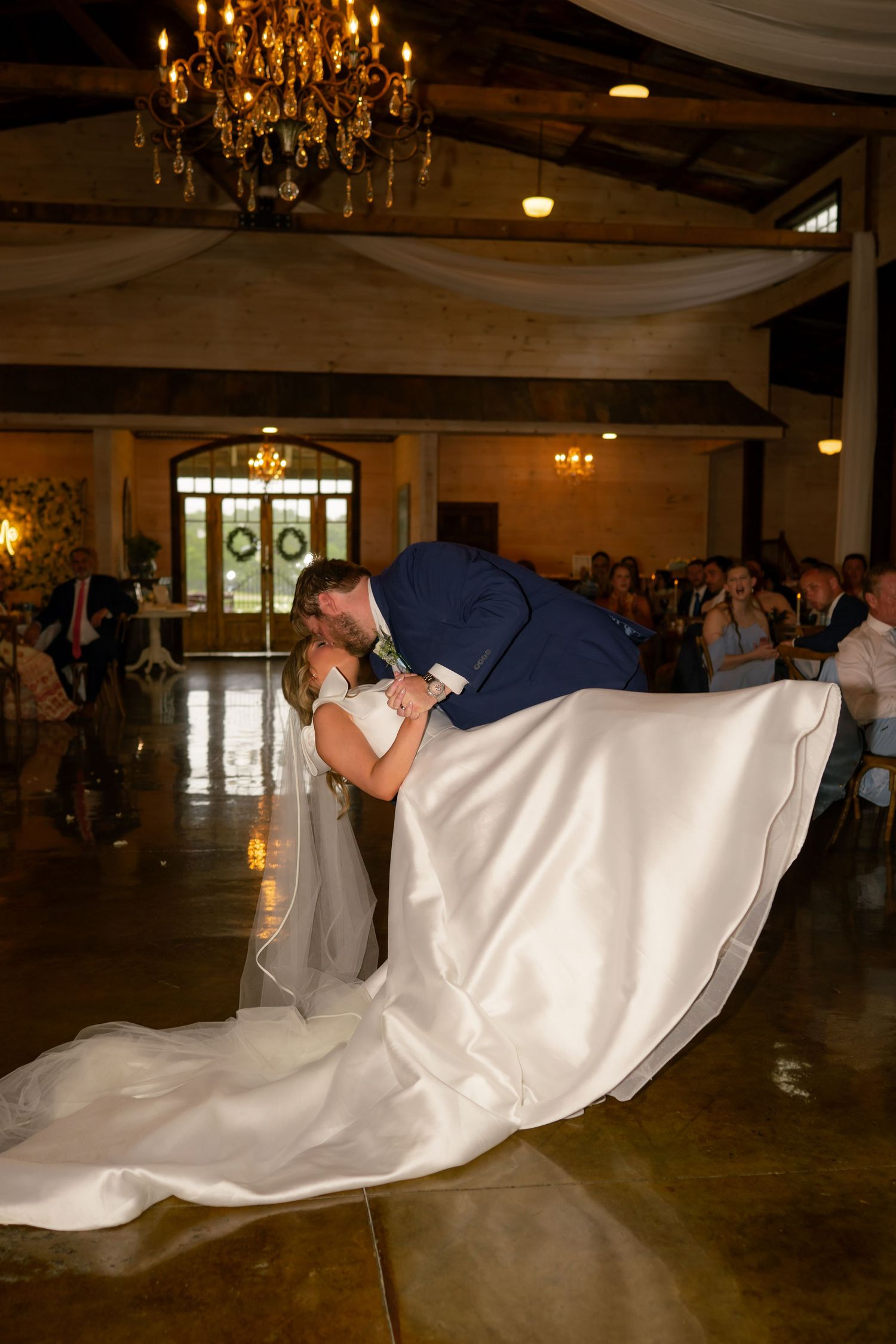 Groom dips bride for a dramatic kiss on the dance floor during their first dance at the reception.