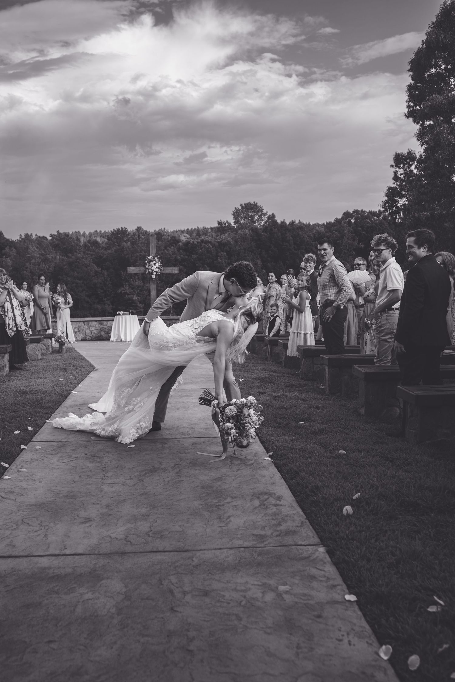 Black and white photo of bride and groom walking down the aisle after their outdoor wedding ceremony.