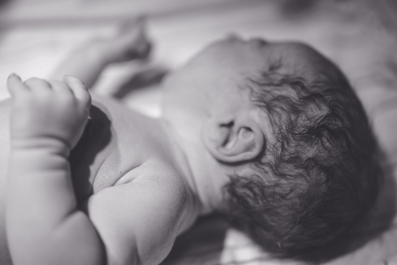 Black and white photo strip showing multiple views of a sleeping baby in peaceful repose.
