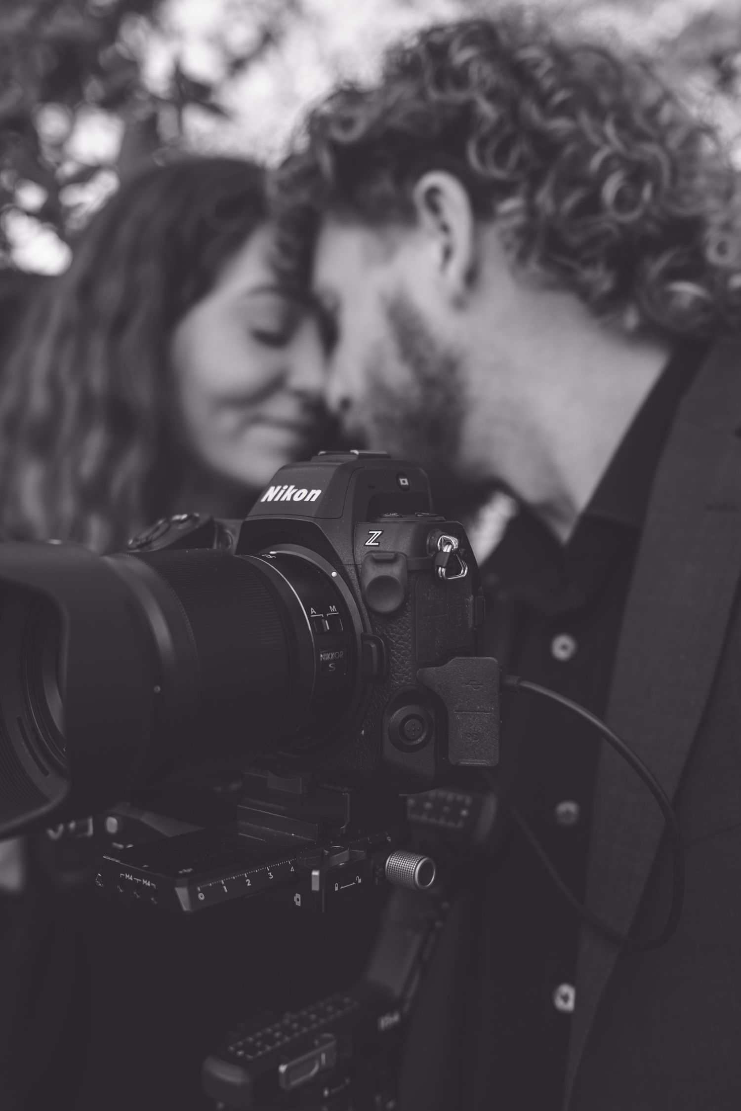 Close-up black and white photo of a Nikon mirrorless camera against a dark background. North Carolina Wedding photographer and videographer